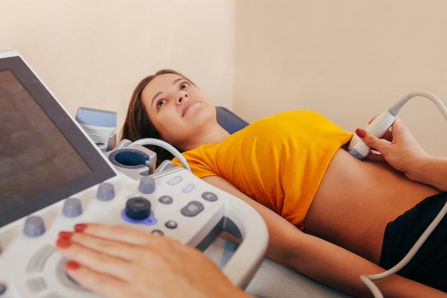 Doctor makes the patient women abdominal ultrasound. Ultrasound Scanner in the hands of a doctor. Diagnostics. Sonography